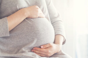 Pregnant woman holding her belly.